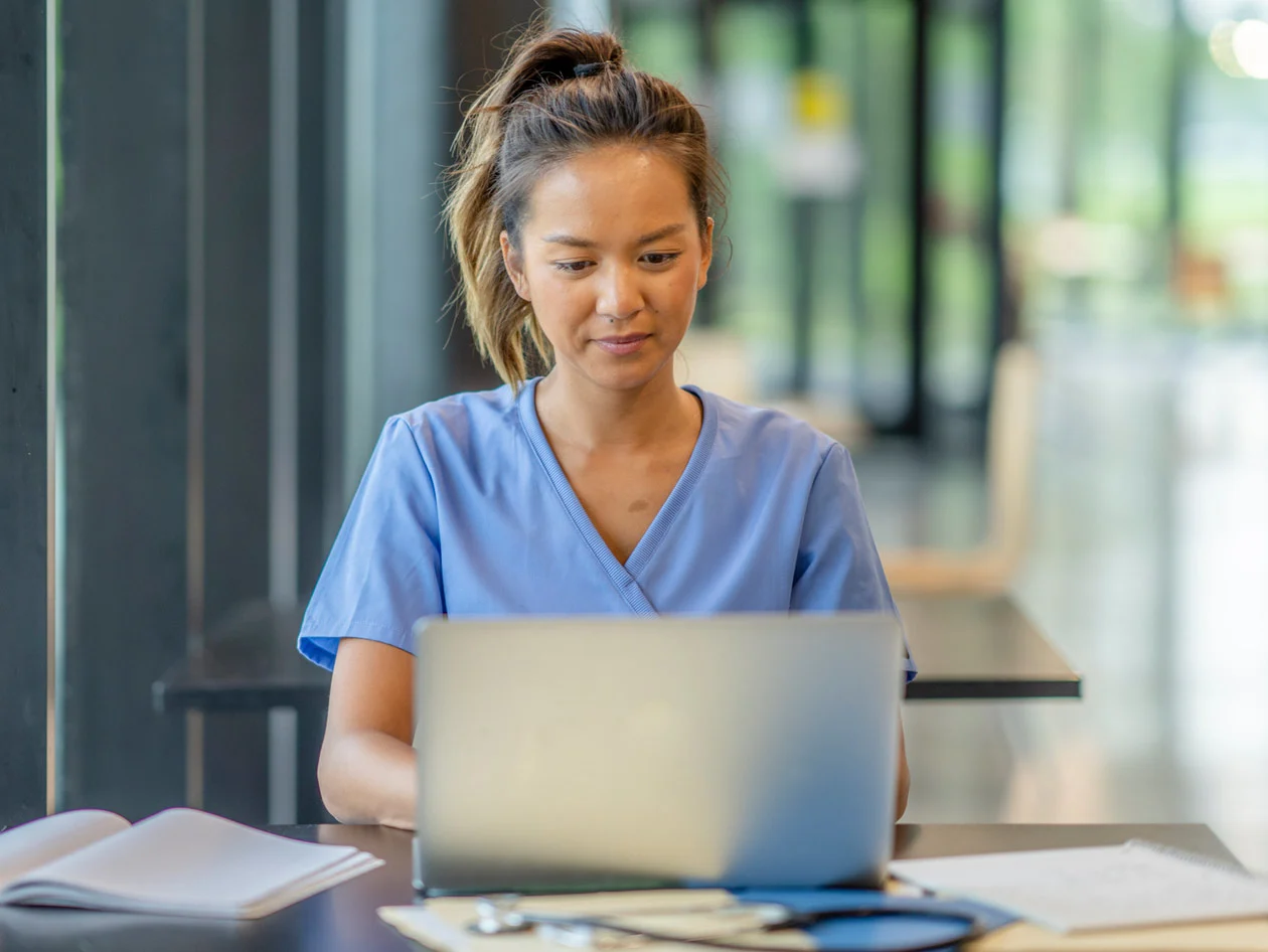 Nurse student studying with books and laptop